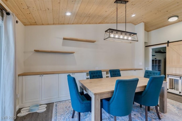 dining area featuring wood ceiling, a barn door, and wood finished floors