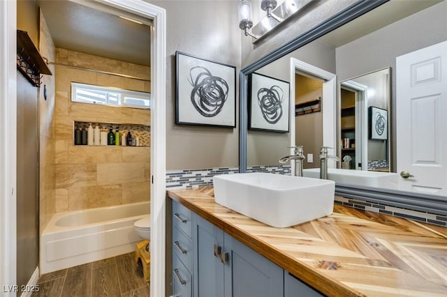 full bathroom featuring tasteful backsplash, toilet, vanity, and shower / tub combination