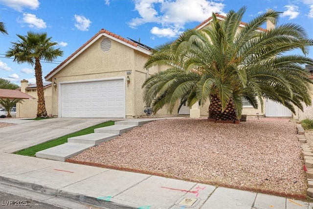 view of front of property with solar panels, stucco siding, concrete driveway, a garage, and a tile roof