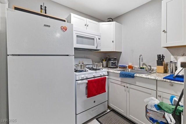 kitchen featuring a sink, white appliances, and white cabinets