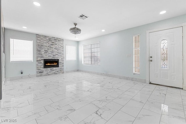 unfurnished living room featuring recessed lighting, baseboards, and a tile fireplace