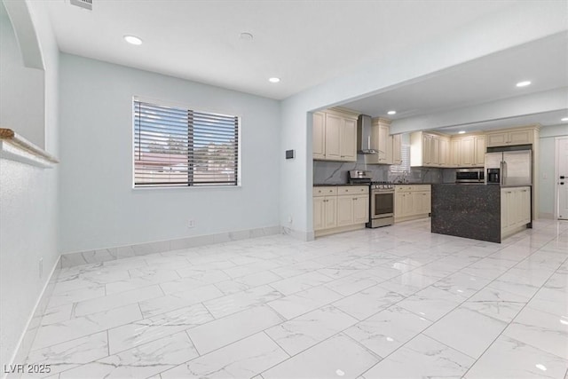 kitchen with stainless steel appliances, cream cabinets, marble finish floor, and wall chimney exhaust hood