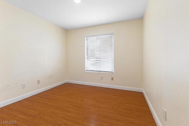 unfurnished room with light wood-type flooring and baseboards