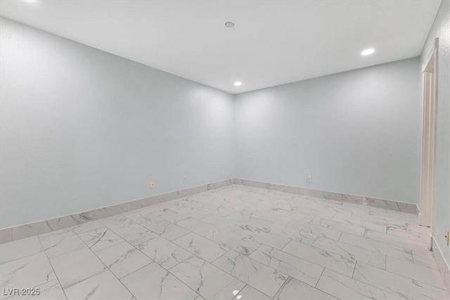 empty room with recessed lighting, baseboards, and marble finish floor