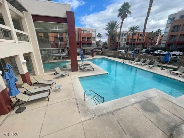 pool with a patio area and fence