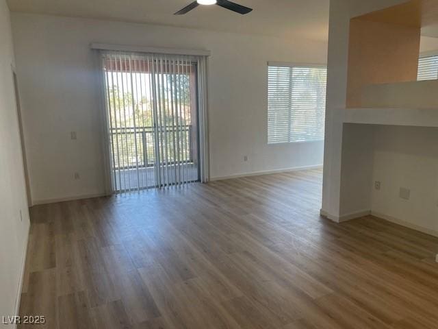 spare room with wood finished floors, baseboards, and ceiling fan