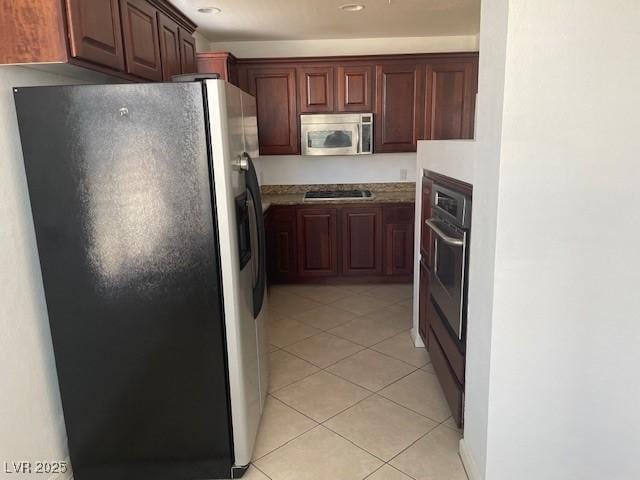 kitchen with light tile patterned floors and stainless steel appliances