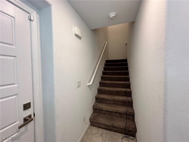 stairs with tile patterned floors and baseboards