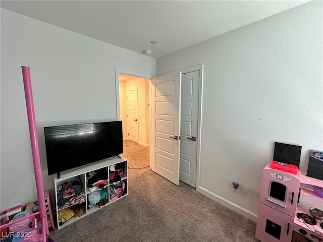 recreation room featuring baseboards and carpet floors