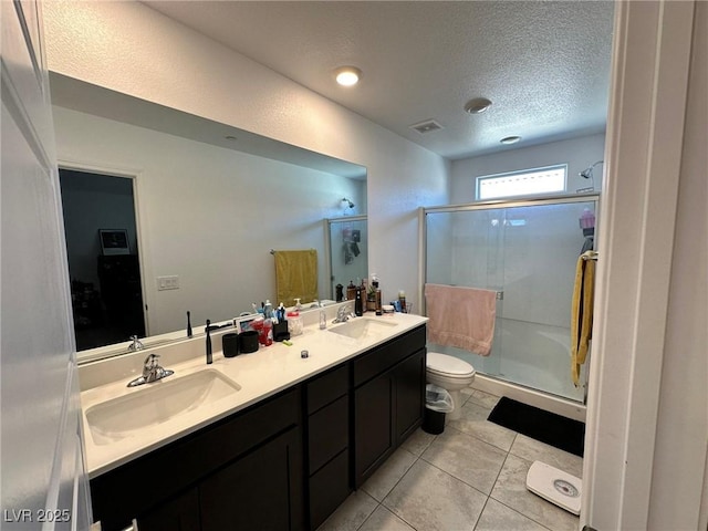 bathroom with a shower stall, a textured ceiling, and a sink