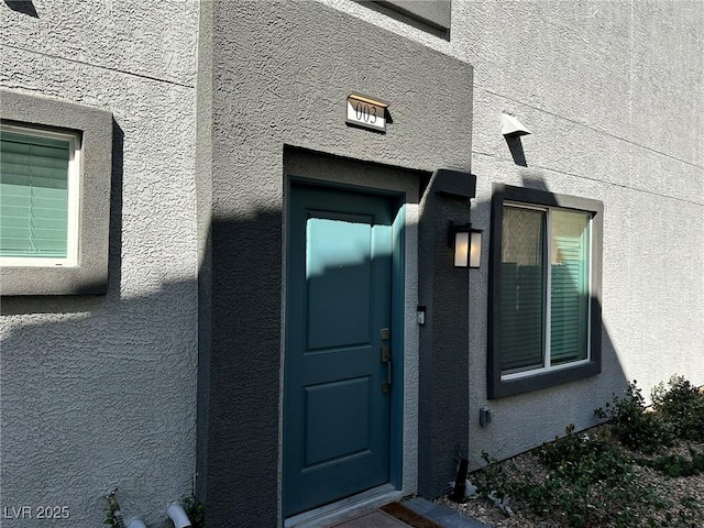 entrance to property featuring stucco siding