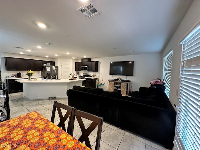 living area with recessed lighting, visible vents, and light tile patterned floors