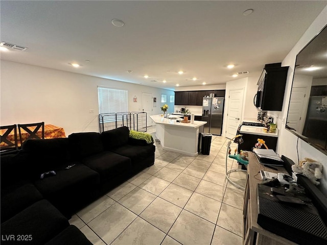 living area with light tile patterned floors, recessed lighting, and visible vents