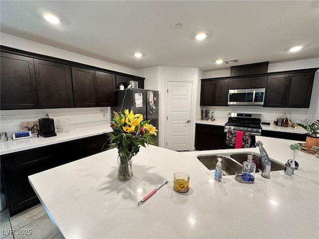 kitchen featuring visible vents, appliances with stainless steel finishes, light countertops, and a sink