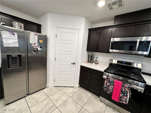 kitchen featuring light countertops, light tile patterned floors, visible vents, and stainless steel appliances