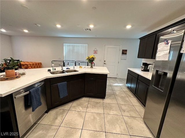 kitchen featuring a sink, stainless steel appliances, light tile patterned floors, and light countertops