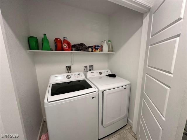 clothes washing area featuring baseboards, light tile patterned flooring, washing machine and dryer, and laundry area