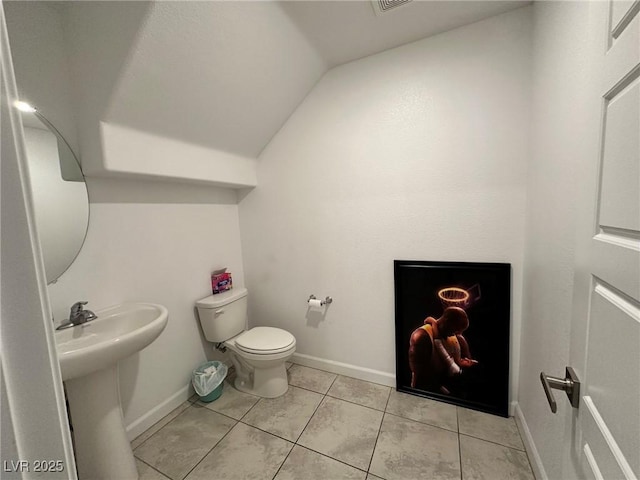 bathroom featuring tile patterned floors, toilet, baseboards, and a sink