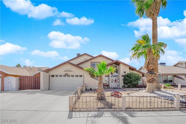 view of front facade featuring an attached garage, a fenced front yard, stucco siding, driveway, and a gate