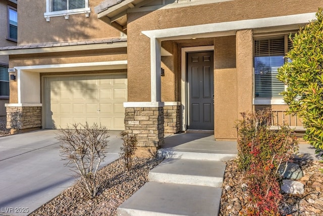 view of exterior entry with stone siding, stucco siding, and concrete driveway