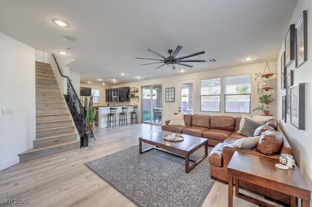 living room featuring recessed lighting, stairway, visible vents, and light wood finished floors