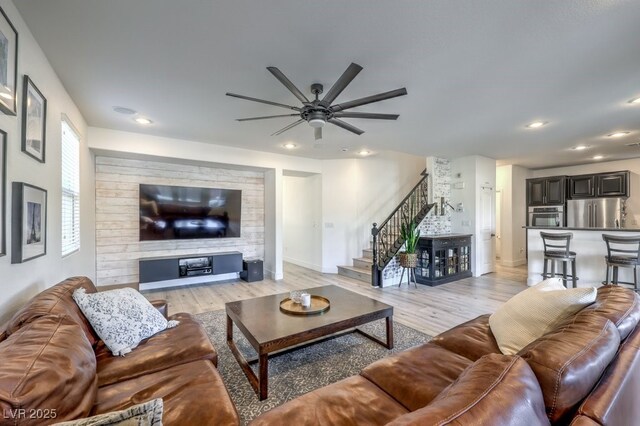 living room featuring stairs, recessed lighting, light wood-style floors, and baseboards