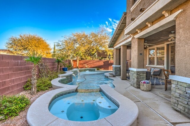 view of swimming pool featuring ceiling fan, a patio, a pool with connected hot tub, and a fenced backyard