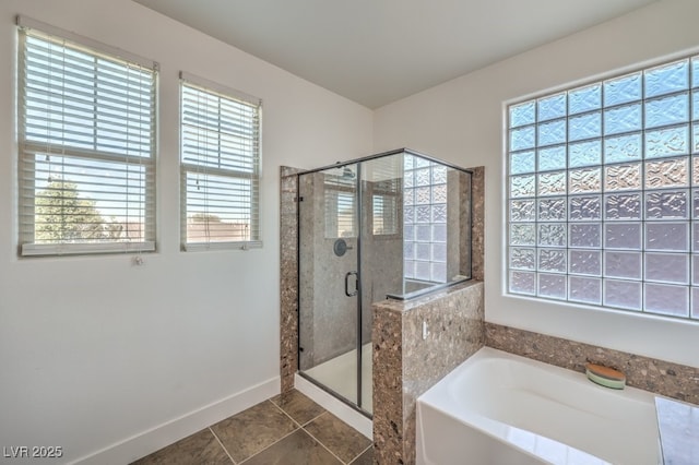 full bath featuring tile patterned flooring, a stall shower, baseboards, and a garden tub