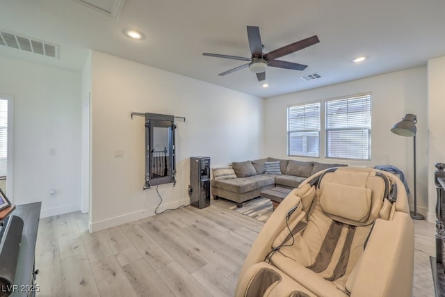 living area featuring a ceiling fan, visible vents, and light wood finished floors