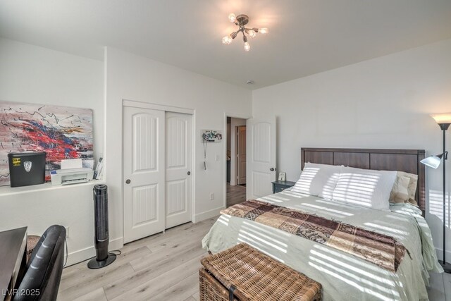 bedroom with baseboards, light wood-type flooring, and a closet