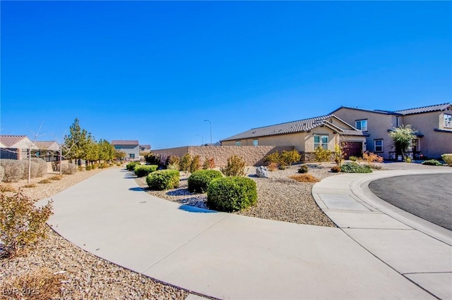 view of front of property featuring a residential view, stucco siding, and fence