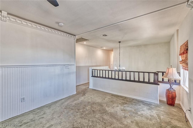 unfurnished room with an inviting chandelier and visible vents