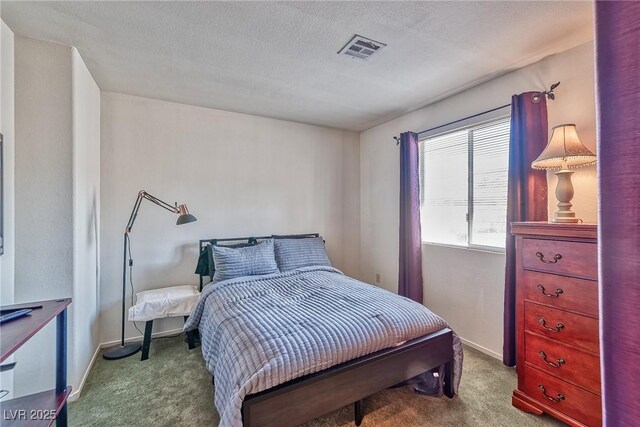 carpeted bedroom with visible vents, a textured ceiling, and baseboards