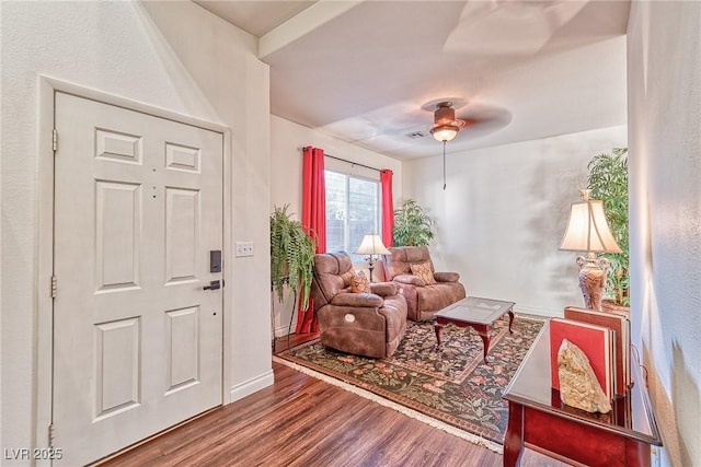 living area featuring ceiling fan, baseboards, and wood finished floors