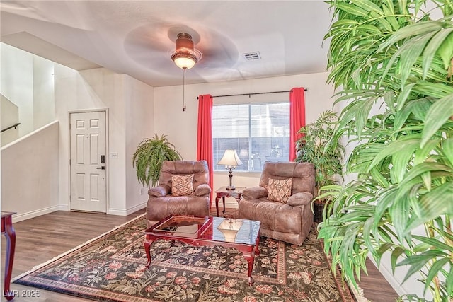 sitting room featuring visible vents, a ceiling fan, baseboards, and wood finished floors