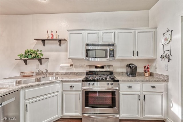 kitchen featuring open shelves, light countertops, appliances with stainless steel finishes, white cabinets, and a sink