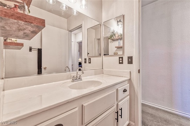 bathroom featuring baseboards, vanity, and a textured wall