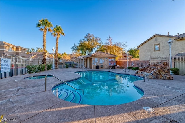 community pool with a patio, a community hot tub, and fence