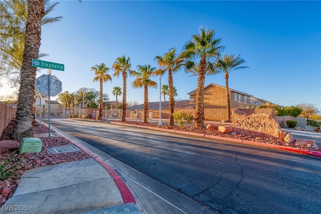 view of road with a gated entry and curbs