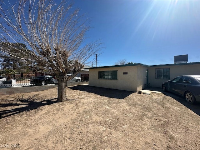 view of front of house with fence and central AC