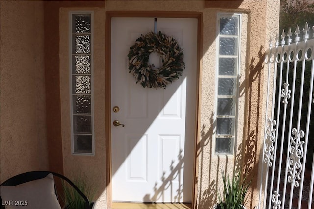 doorway to property featuring stucco siding