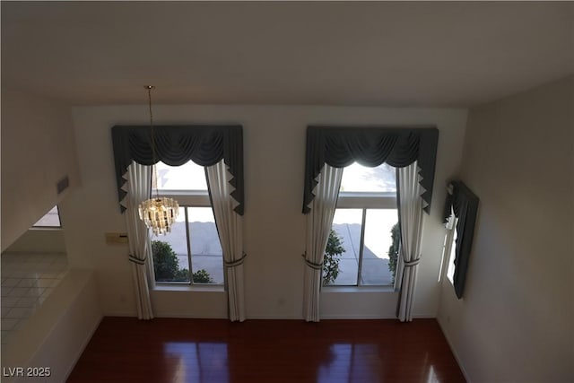 foyer entrance featuring dark wood finished floors, an inviting chandelier, baseboards, and visible vents