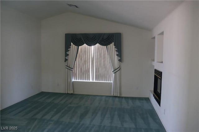 unfurnished living room featuring visible vents, carpet, a glass covered fireplace, and vaulted ceiling