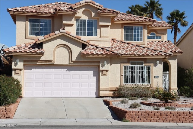 mediterranean / spanish-style home featuring a garage, driveway, and stucco siding