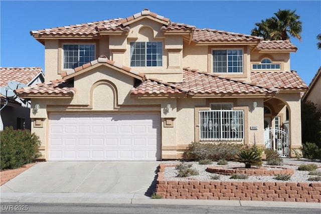 mediterranean / spanish house featuring stucco siding, an attached garage, and concrete driveway