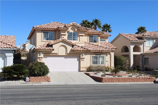 mediterranean / spanish-style house with concrete driveway, a tiled roof, an attached garage, and stucco siding