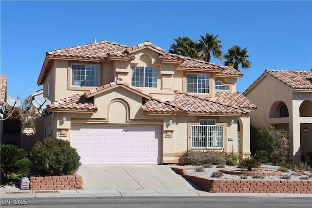 mediterranean / spanish-style home featuring concrete driveway, an attached garage, and stucco siding