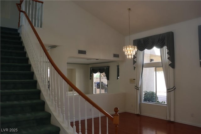 foyer featuring visible vents, high vaulted ceiling, an inviting chandelier, and wood finished floors