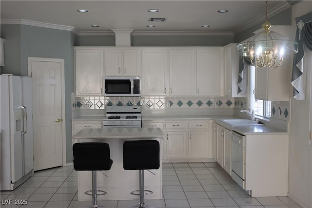 kitchen featuring visible vents, light countertops, white appliances, white cabinetry, and a sink