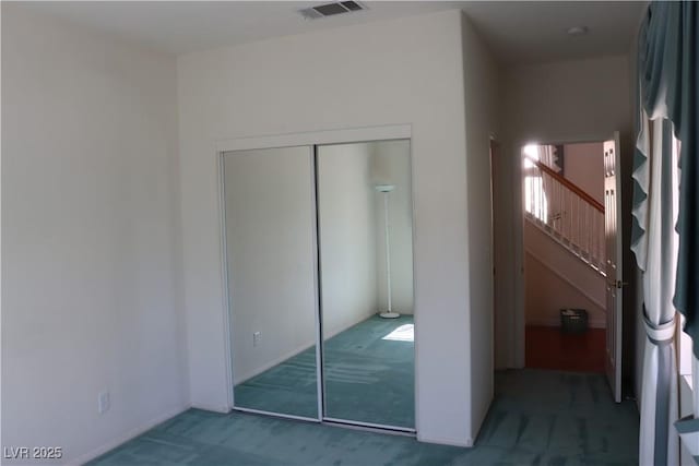 unfurnished bedroom featuring visible vents, carpet, and a closet